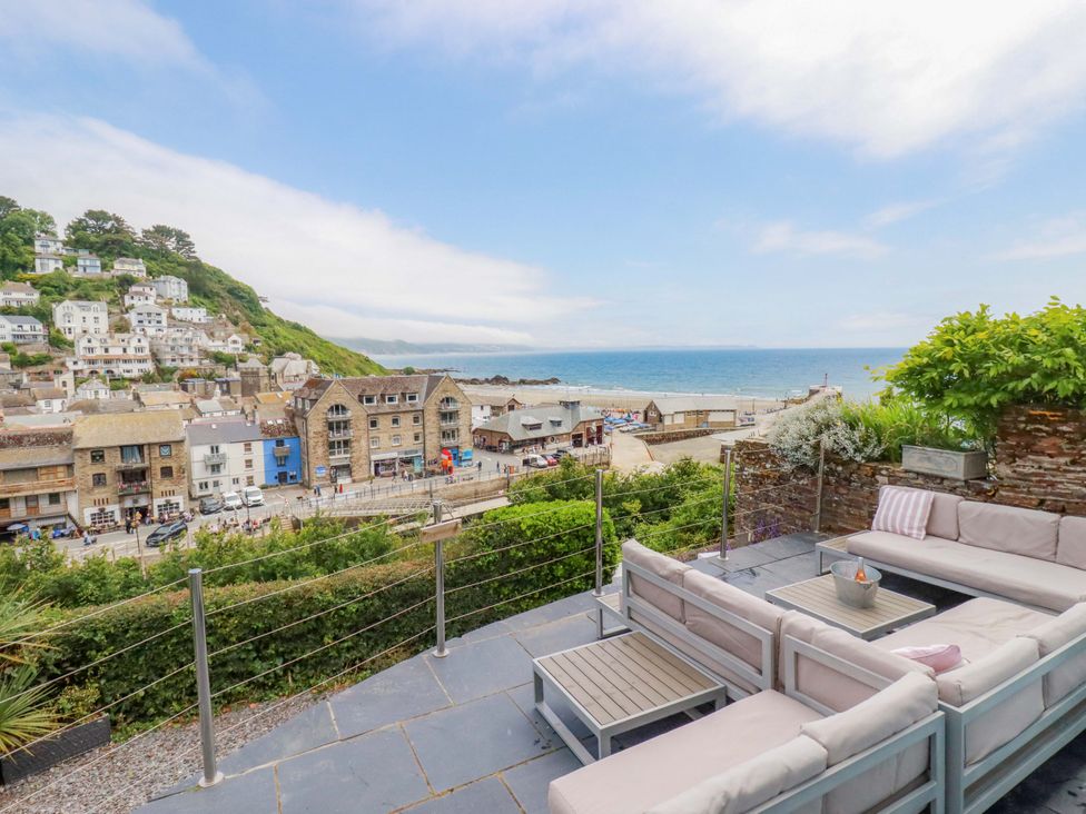A seating area with a view of houses and ocean at Harbour House in Looe