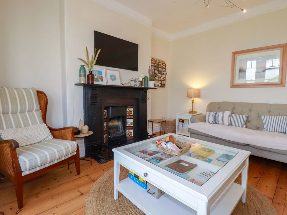 A living room with a sofa and coffee table at Harbour House in Looe