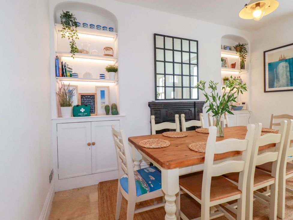 A dining room with a table and chairs at Harbour House in Looe