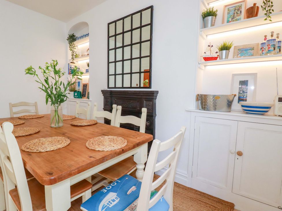 A dining room with a wooden table and chairs at Harbour House in Looe