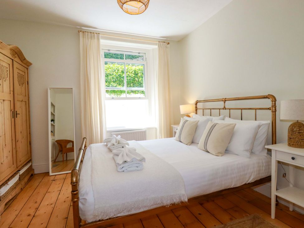 A bedroom with a bed and wardrobe at Harbour House in Looe