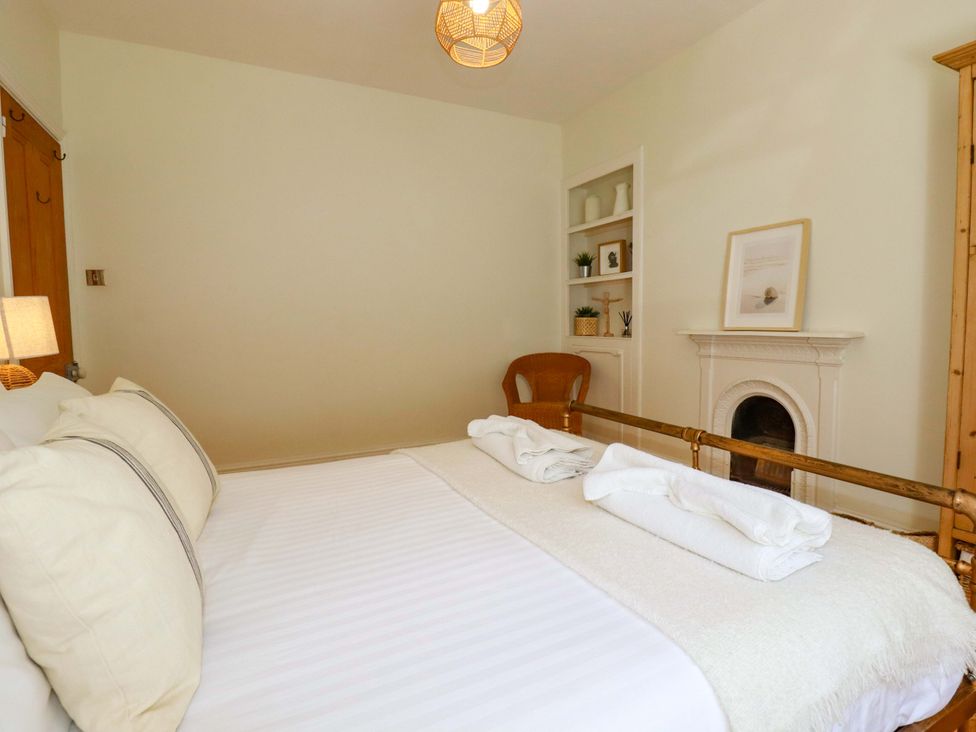 A bedroom with a bed and a shelf at Harbour House in Looe