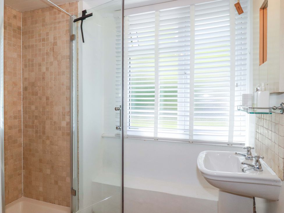 A bathroom with a shower and sink at Harbour House Looe