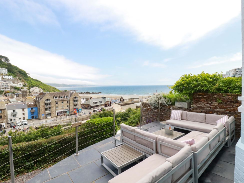 An outdoor patio with seating and a view of the sea at Harbour House in Looe