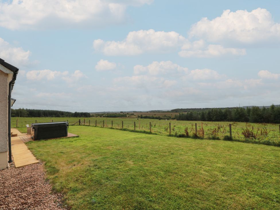 A garden with a hot tub and field at The Dairy in Airdrie