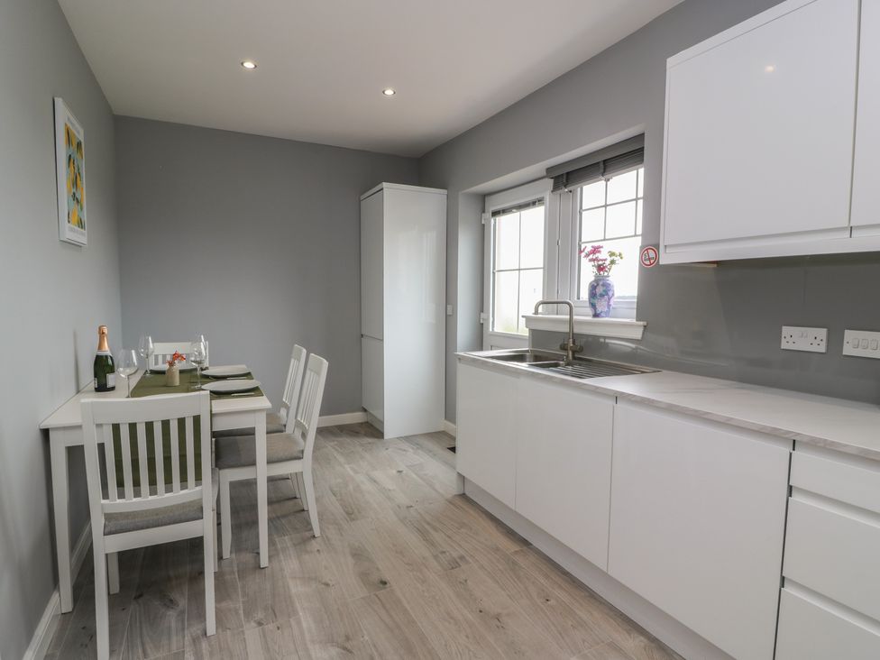 A kitchen with a dining table and chairs at The Dairy in Airdrie
