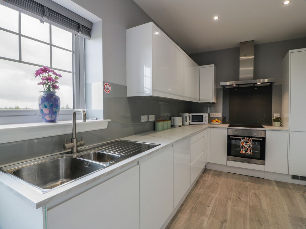 A kitchen with a sink and oven at The Dairy in Airdrie