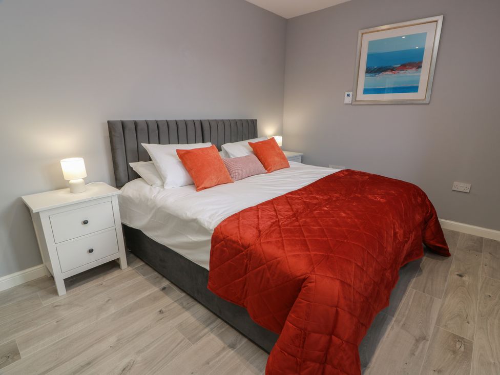 A bedroom with a bed and bedside table at The Dairy in Airdrie