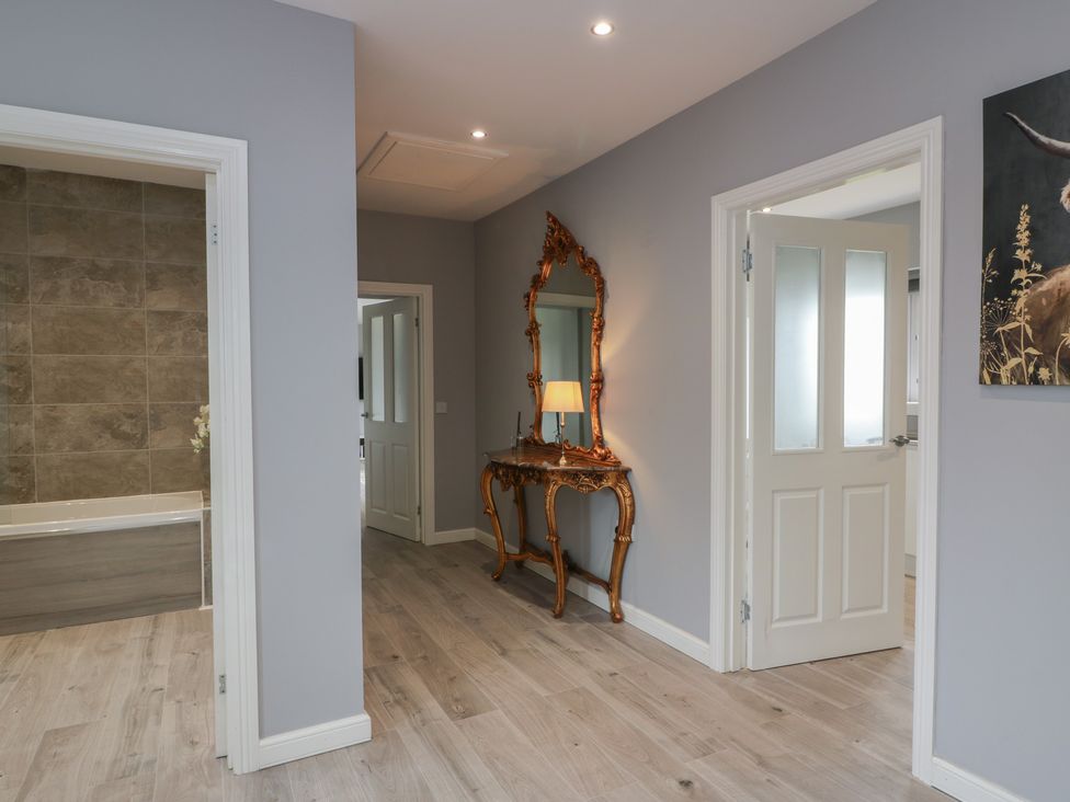 A hallway with a console table and mirror at The Dairy in Airdrie