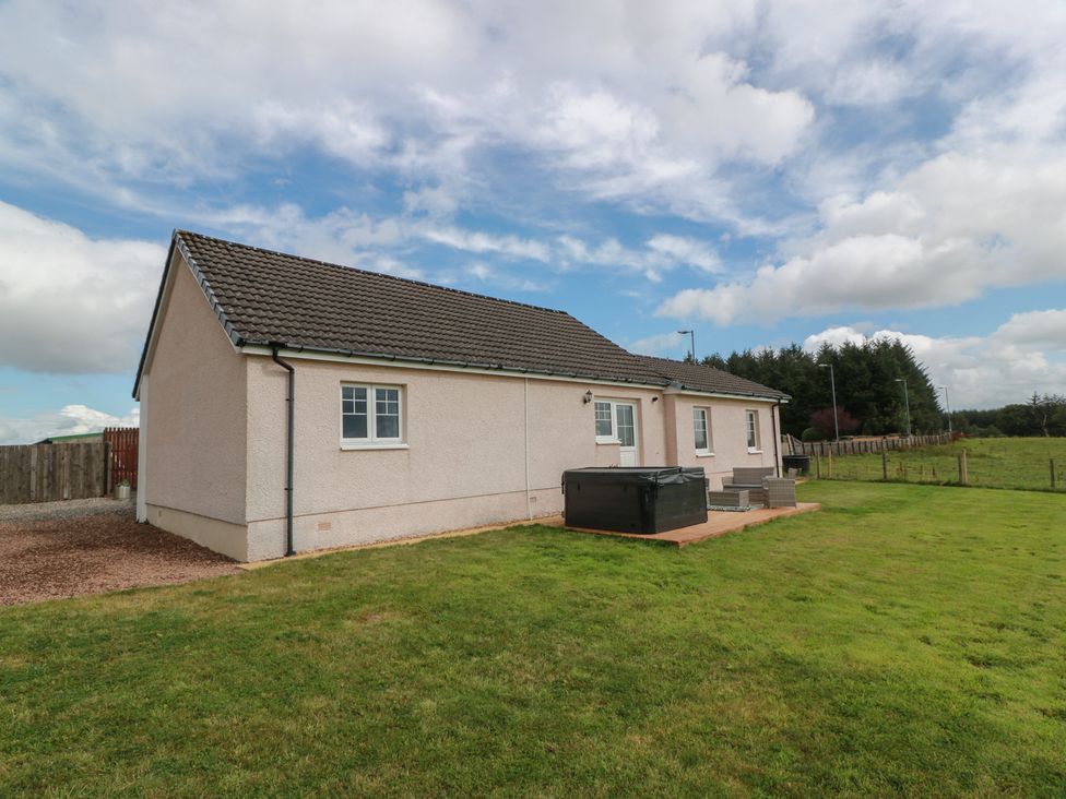 A house with grass and a deck at The Dairy in Airdrie
