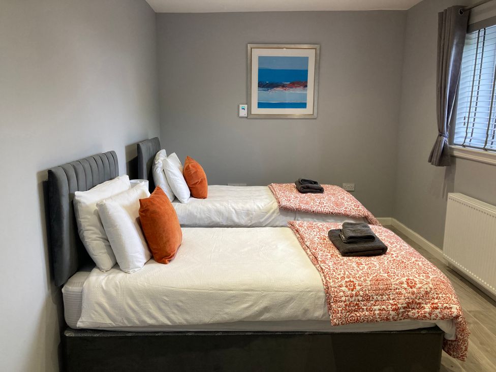 A bedroom with two beds and a painting at The Dairy in Caldercruix