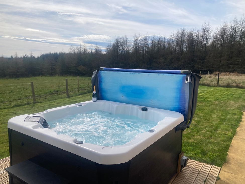 A hot tub with bubbling water and a bottle of champagne at The Dairy Caldercruix