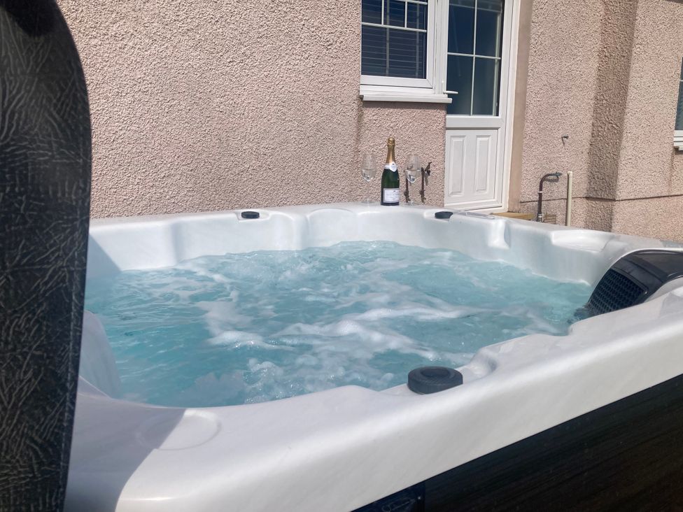 A hot tub with champagne and glasses at The Dairy in Caldercruix