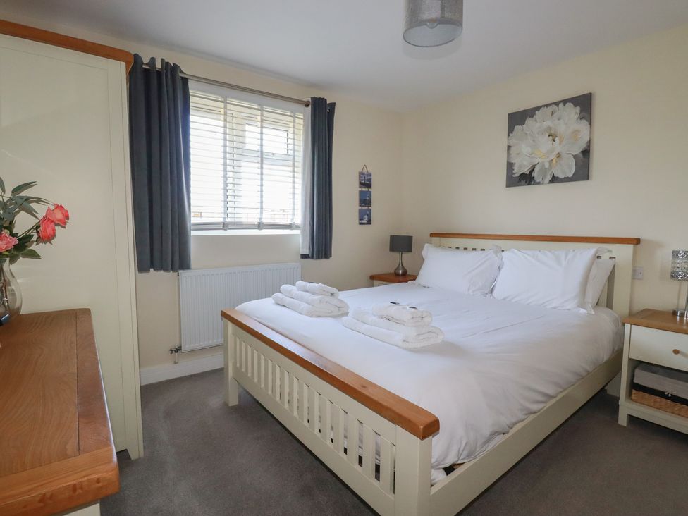 A bedroom with a double bed and bedside tables with lamps at Lodge 18 in St Merryn