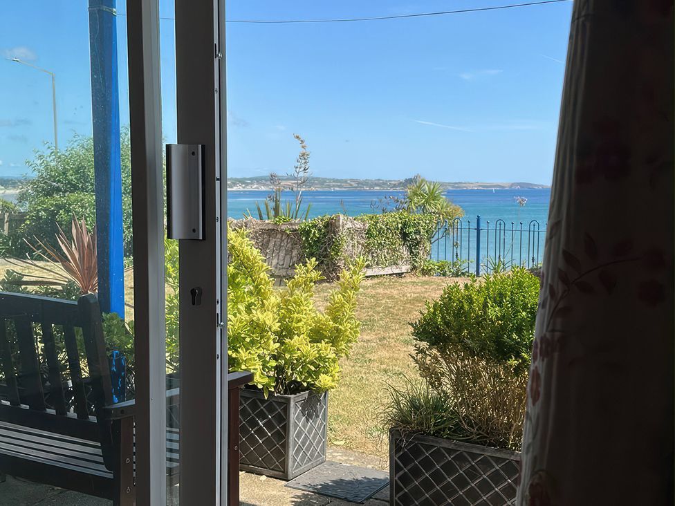 An outdoor view featuring a bench and plants at 1 Penrose Court Penzance