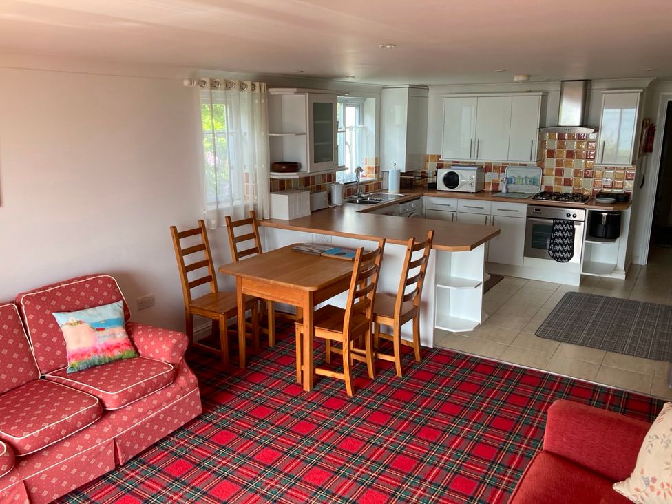 A kitchen with a dining area and appliances at 1 Penrose Court in Penzance