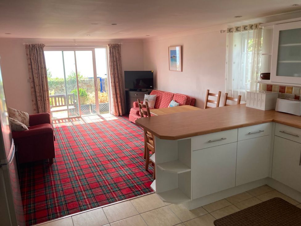 A living room with a sofa and table at 1 Penrose Court in Penzance