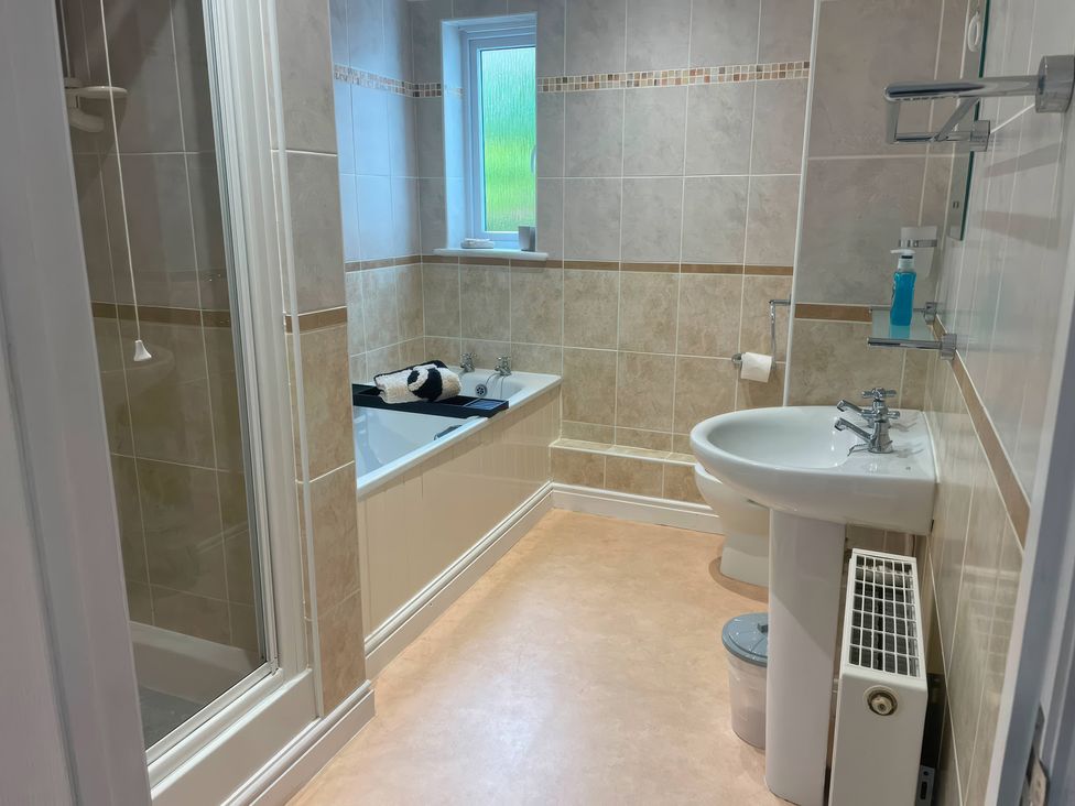 A bathroom with a bathtub, shower, sink, and toilet at Tide Watch in Penzance