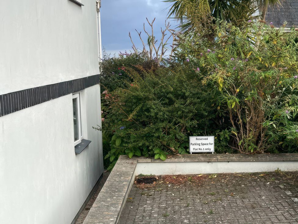 An outdoor area featuring a parking sign and surrounding bushes at Tide Watch in Penzance