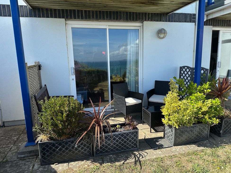 An outdoor seating area with chairs and plants at Tide Watch in Penzance