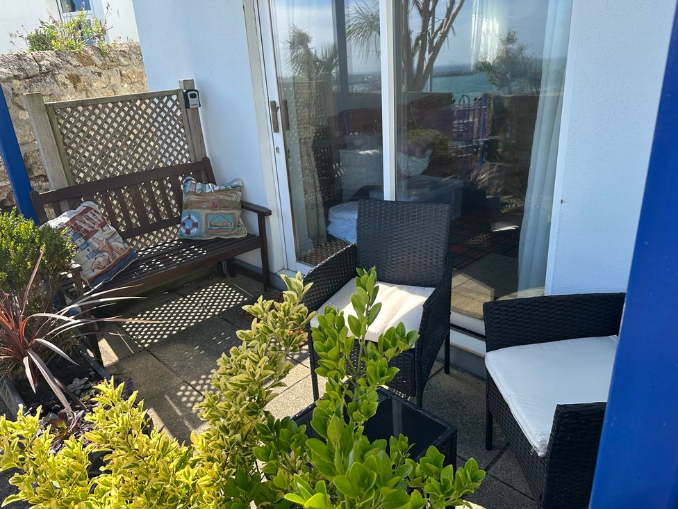 An outdoor patio with seating and plants at Tide Watch in Penzance