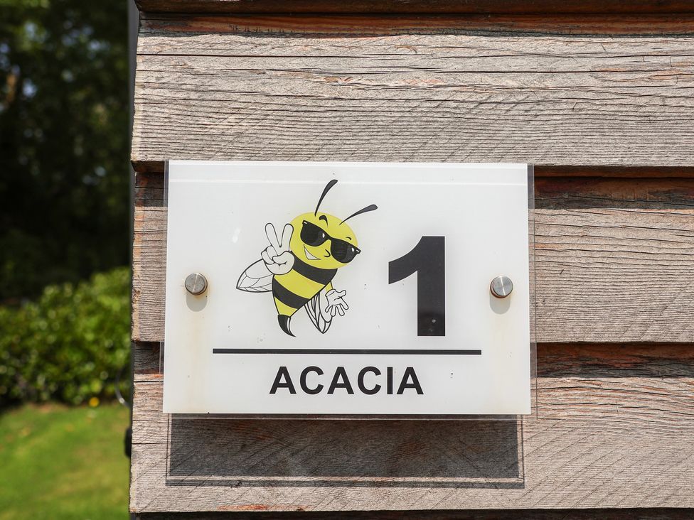 A sign featuring a bee illustration and the number 1 at Honeypot Hideaways - Acacia