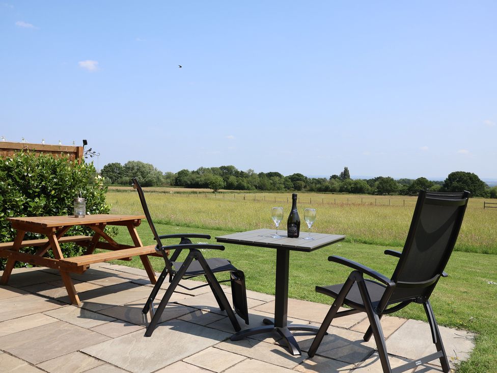 An outdoor seating area with chairs and a table at Honeypot Hideaways - Acacia