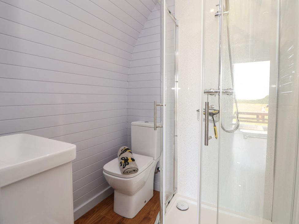 A bathroom featuring a shower, toilet, and sink at Honeypot Hideaways - Acacia