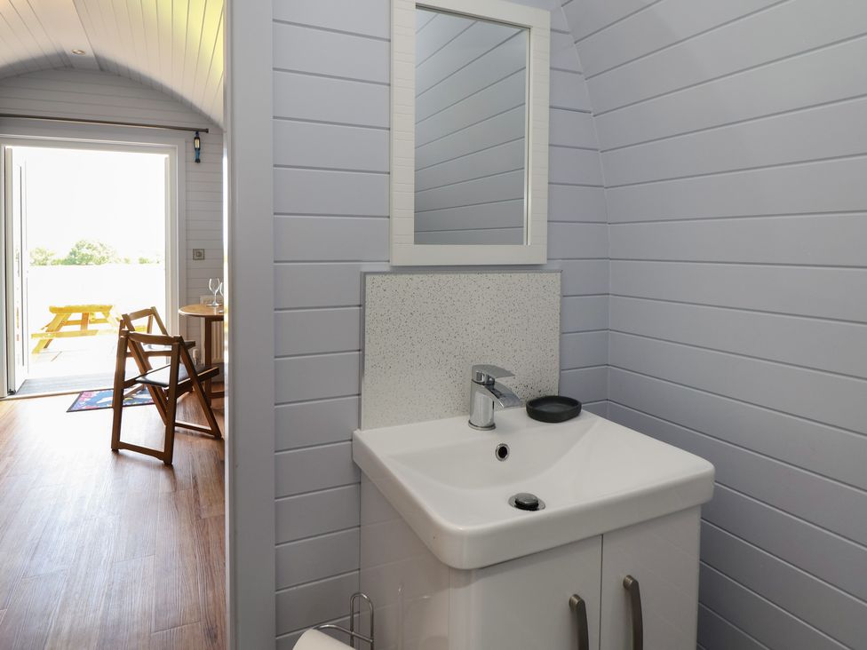 A bathroom with a sink and mirror at Honeypot Hideaways - Acacia