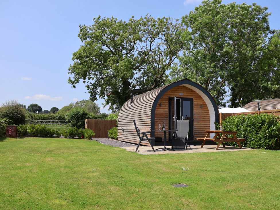 A cabin with outdoor seating at Honeypot Hideaways - Acacia