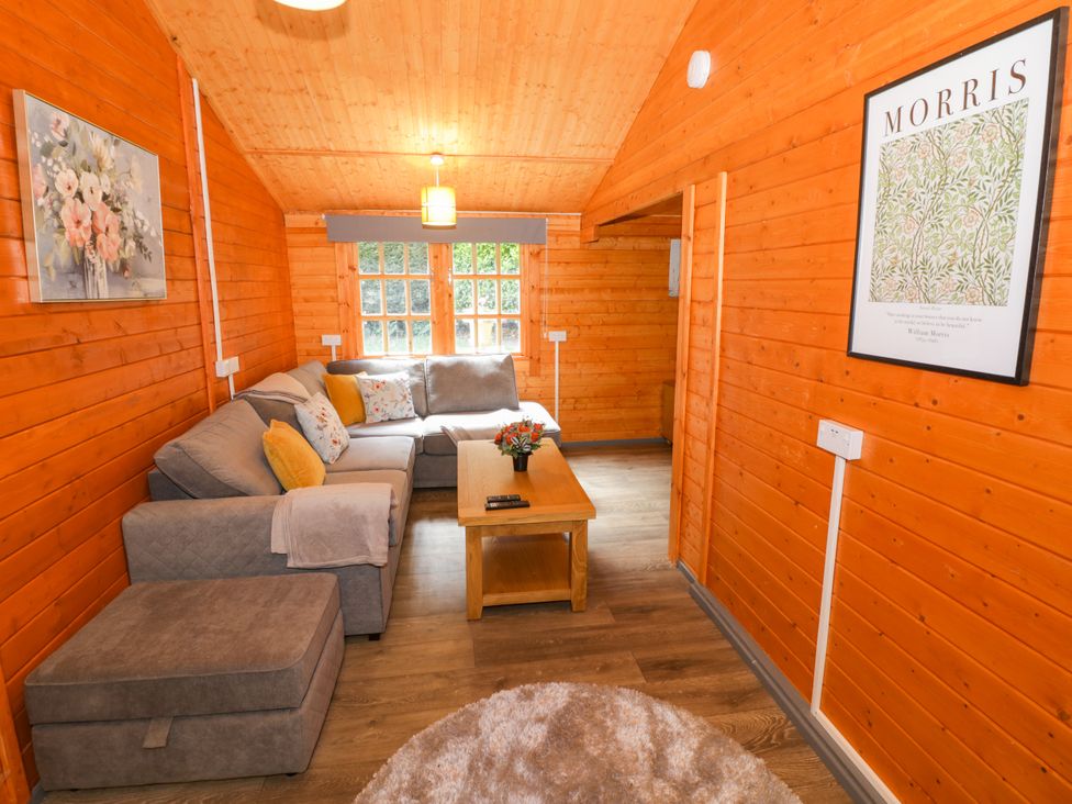 A living room with a sofa and coffee table at Stumps Cross Lodge in Upper Coscombe near Winchcombe