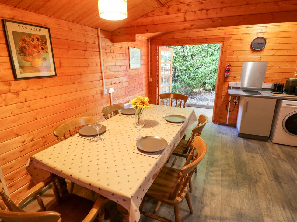 A dining room with a table and chairs at Stumps Cross Lodge in Upper Coscombe near Winchcombe