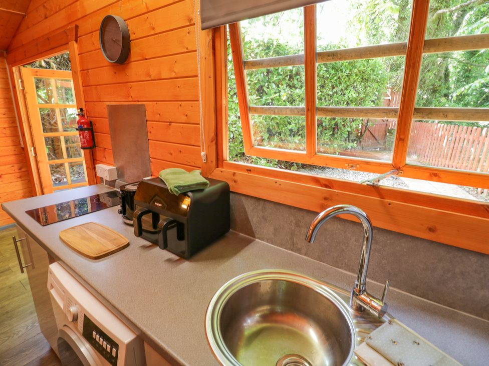 A kitchen with a sink, toaster, and fire extinguisher at Stumps Cross Lodge Upper Coscombe near Winchcombe
