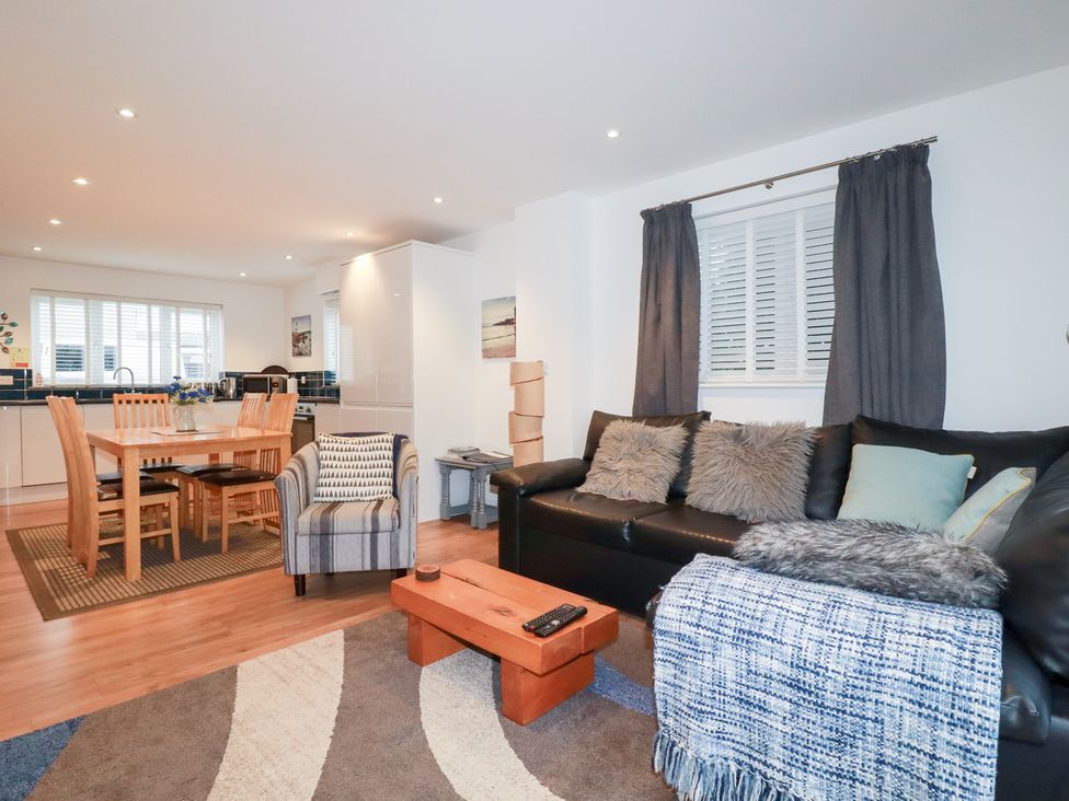 A living room with a dining area and kitchen at Fistral Palms 2