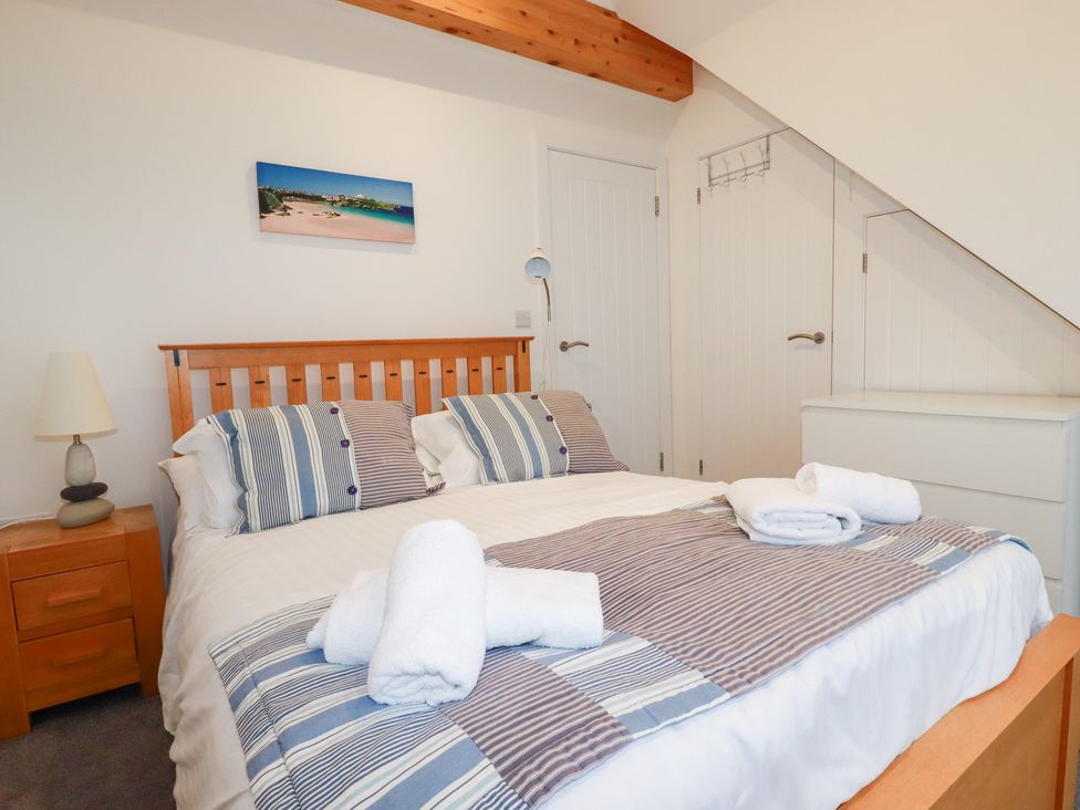 A bedroom with a bed and bedside table at Fistral Palms 2
