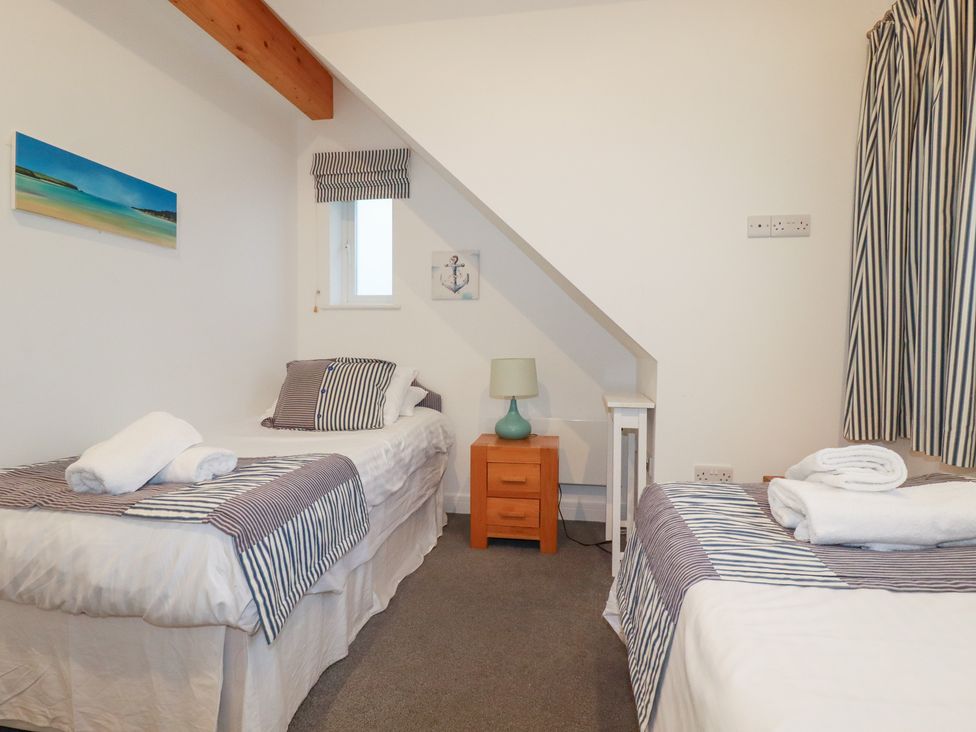 A bedroom with two beds and a lamp at Fistral Palms 2 in 