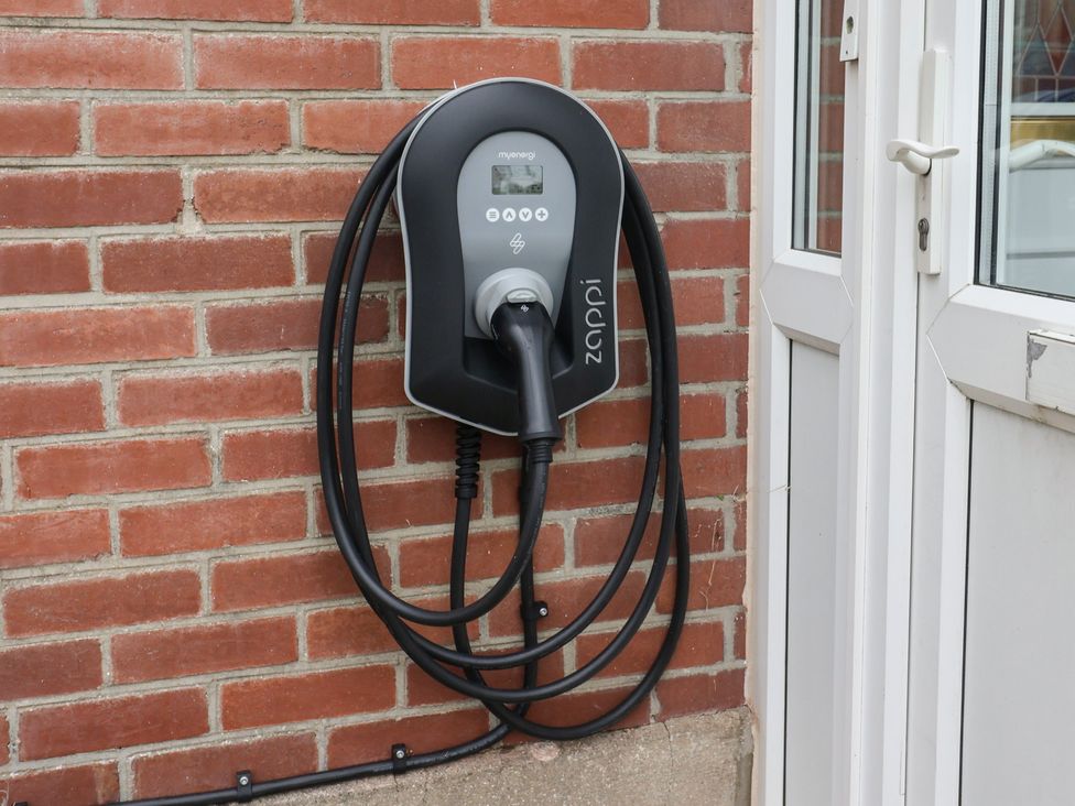 An electric vehicle charger mounted on a brick wall at 20 Lym Close