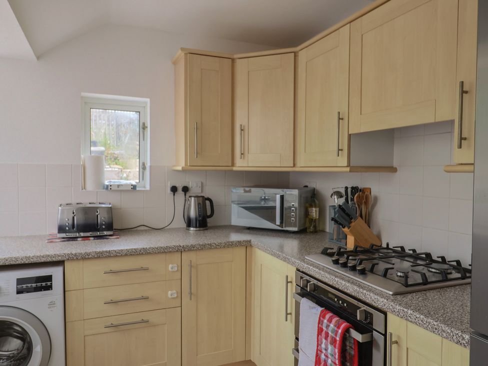 A kitchen with appliances and cabinets at 20 Lym Close in Lyme Regis