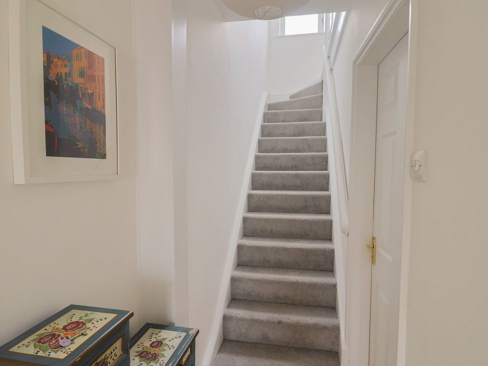 A staircase and storage boxes in a hallway at 20 Lym Close in Lyme Regis