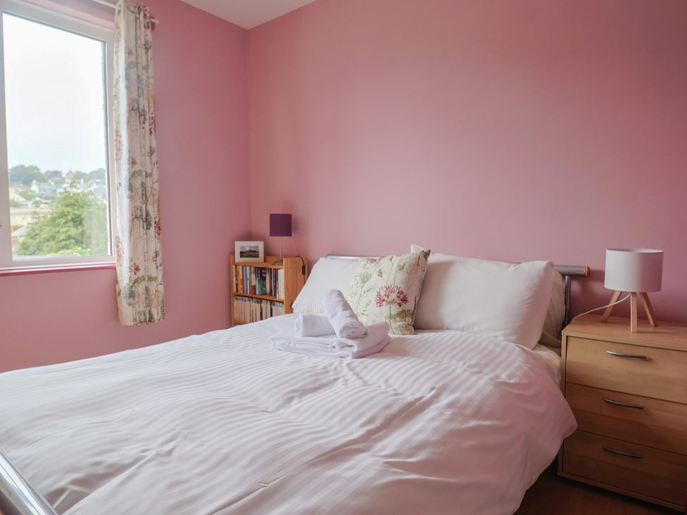 A bedroom with a bed and bookshelf at 20 Lym Close in Lyme Regis