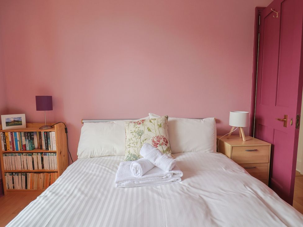 A bedroom with a bed and bookshelf at 20 Lym Close, Lyme Regis