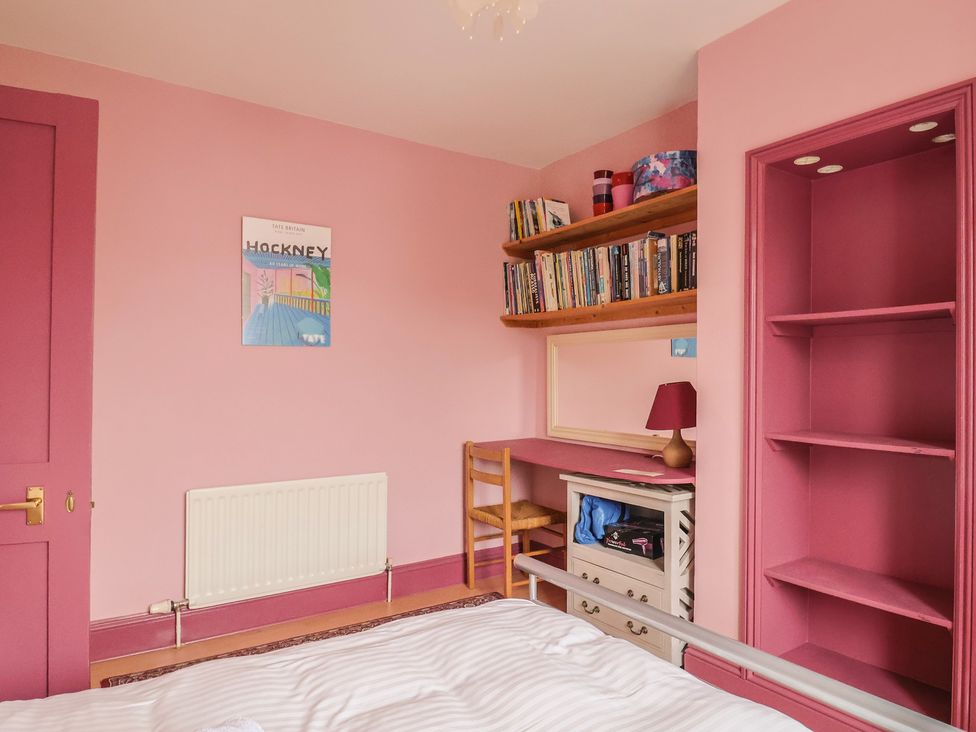 A bedroom with a bed, desk, and bookshelf at 20 Lym Close in Lyme Regis