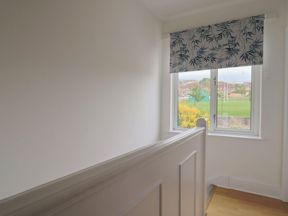 A landing with a window and curtain at 20 Lym Close in Lyme Regis