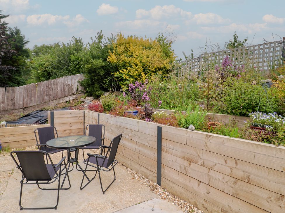 A garden with a table and chairs at 20 Lym Close in Lyme Regis