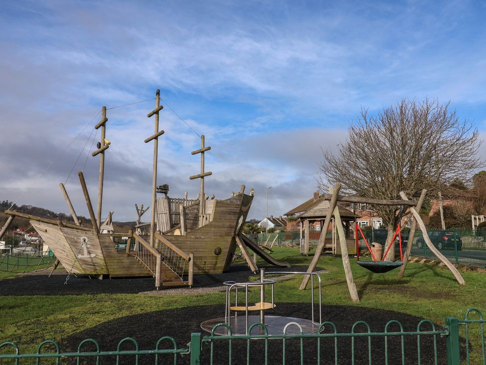 A playground with a pirate ship play structure and swings at 20 Lym Close in Lyme Regis