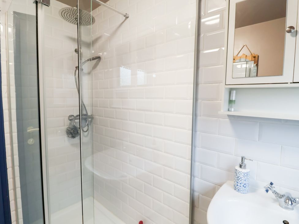 A shower with glass door and sink at Deben Road in Woodbridge