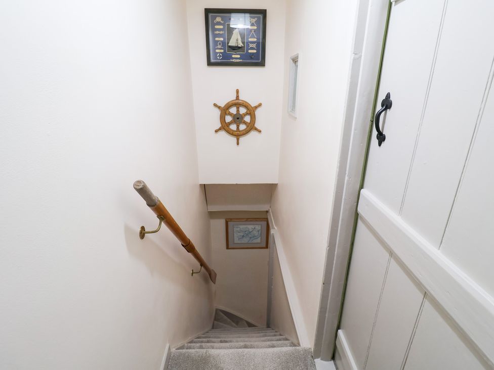 A staircase with a handrail and nautical decor at Deben Road in Woodbridge