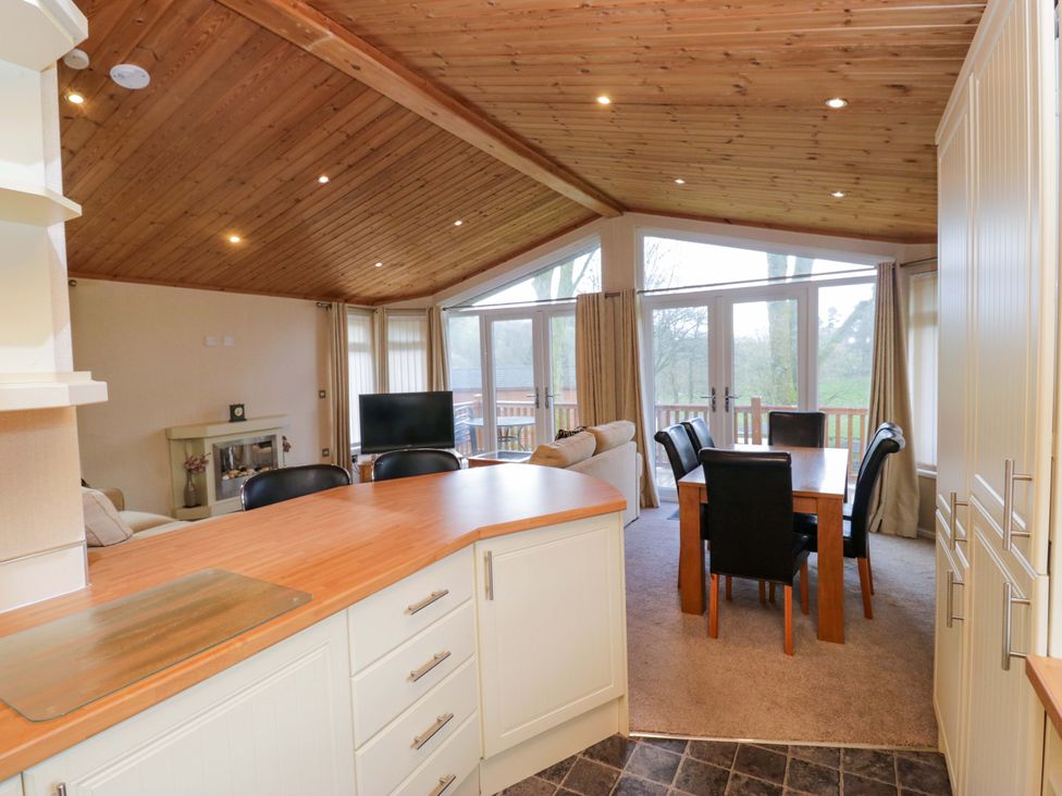 A living room with a dining area and television at Wansfell 2 in Limefitt Park near Troutbeck