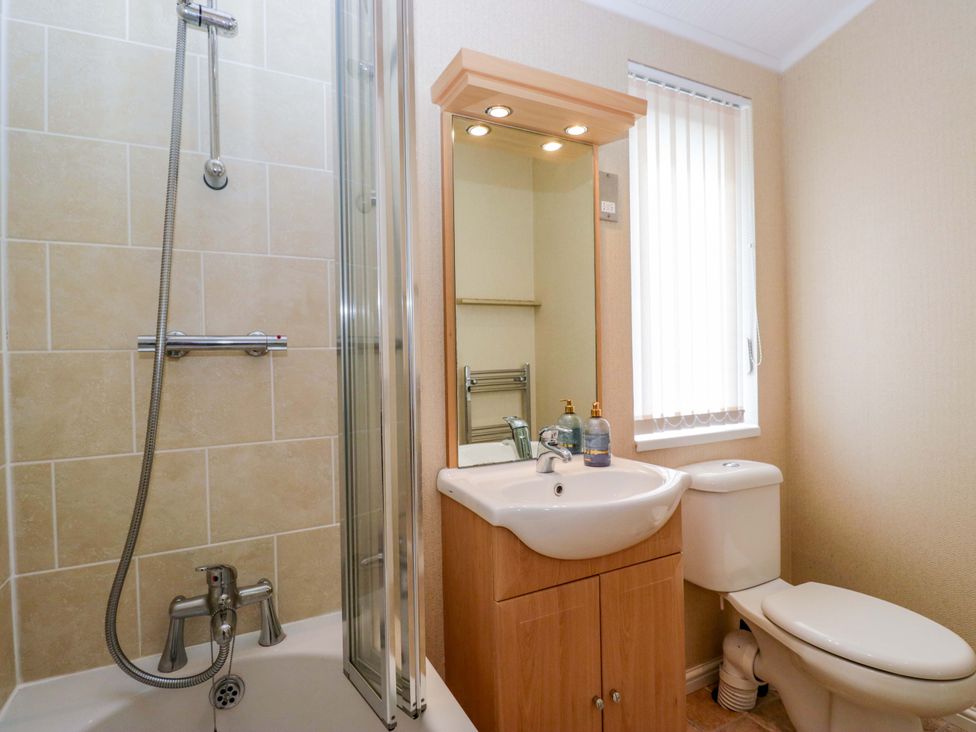 A bathroom with a shower, sink and toilet at Wansfell 2 Limefitt Park near Troutbeck