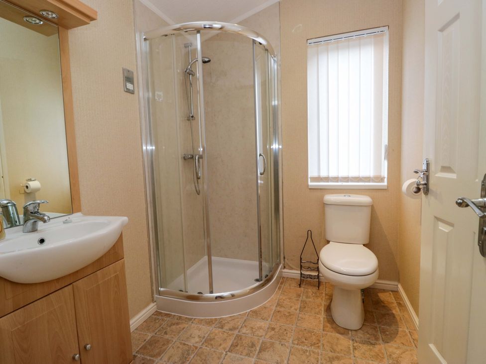 A bathroom featuring a shower, toilet, and sink at Wansfell 2 Limefitt Park near Troutbeck